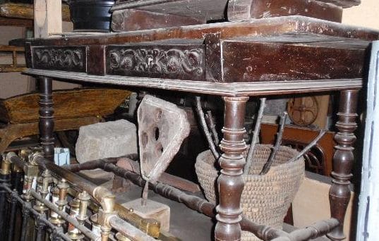 mesa antigua dos cajones expuesta en la tienda de Artesanos Leoneses